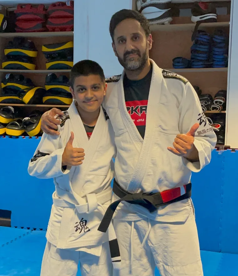 Coach Jag with a young student giving thumbs up